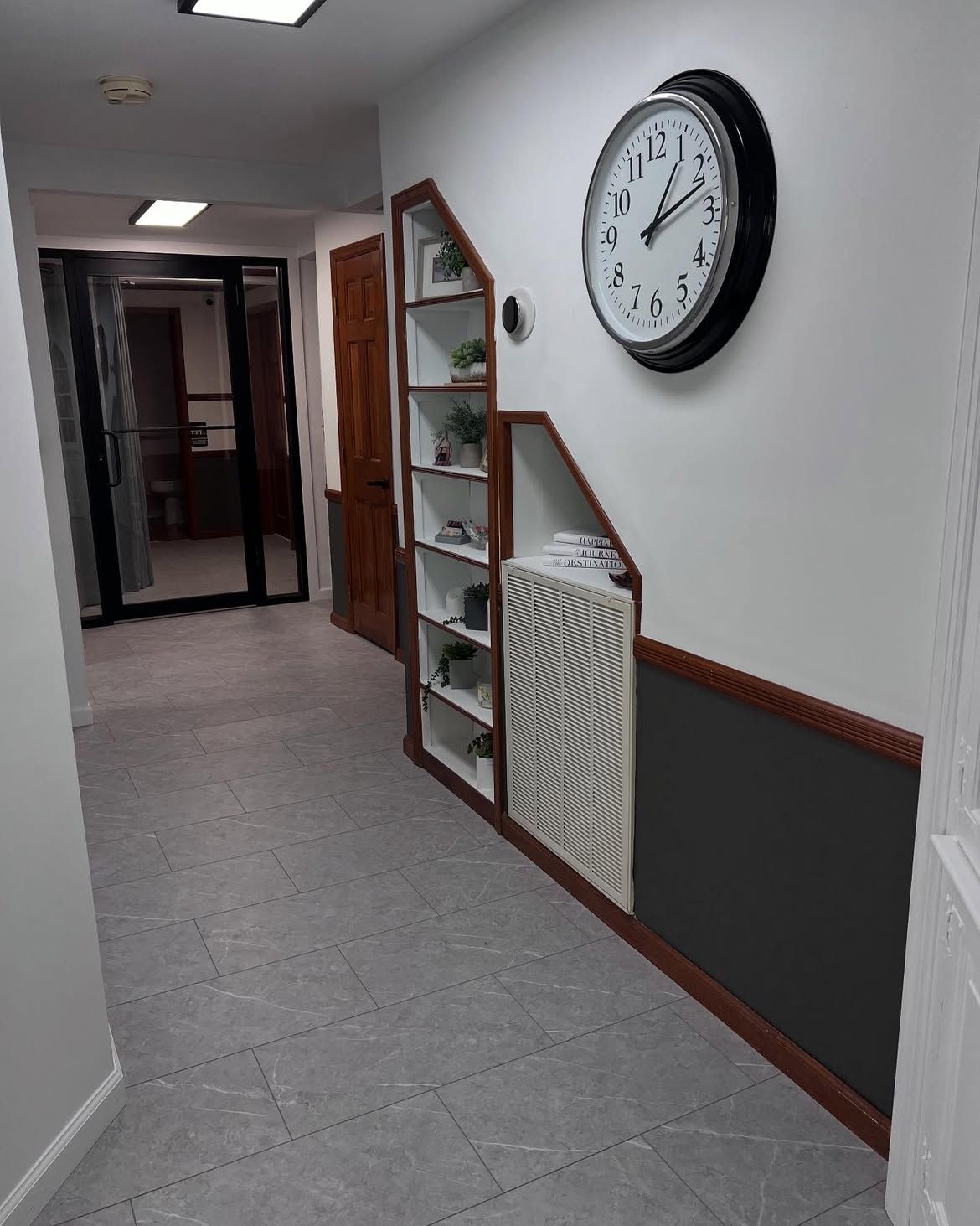 The ground-floor corridor at the Wading River clinic, leading past a shelving nook to the accessible restroom.