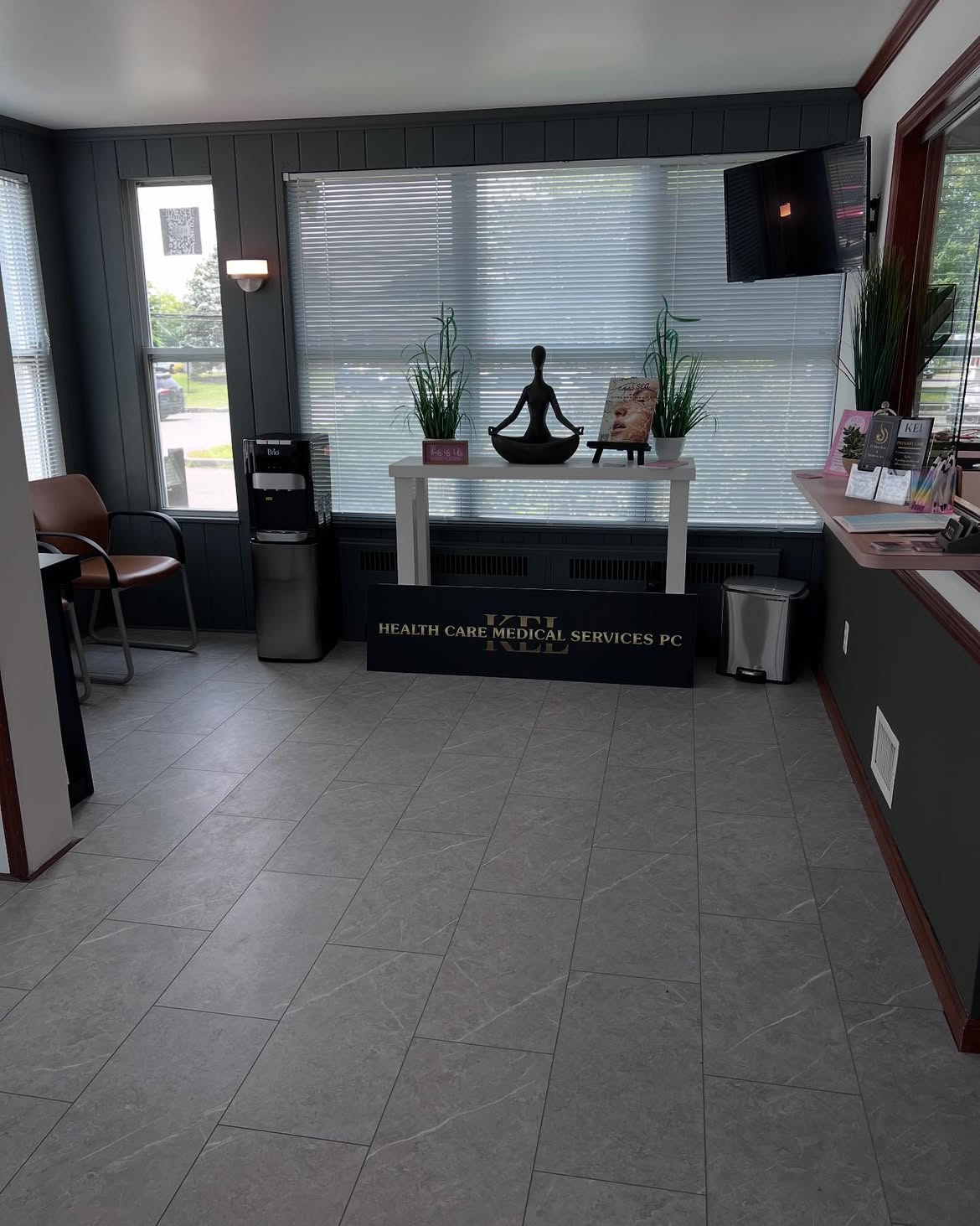The front lobby at the Wading River clinic, with seating by the window, a water cooler and the Kel Healthcare Medical Services sign.