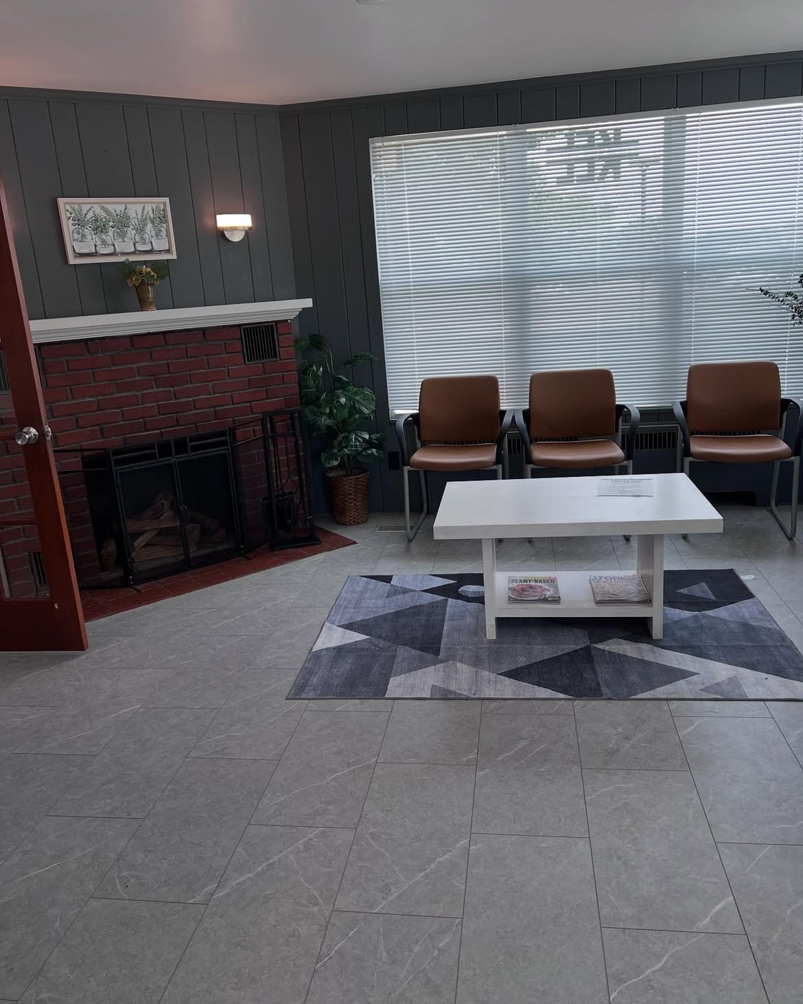 The Wading River waiting room, with armchairs arranged around a low table beside the fireplace.