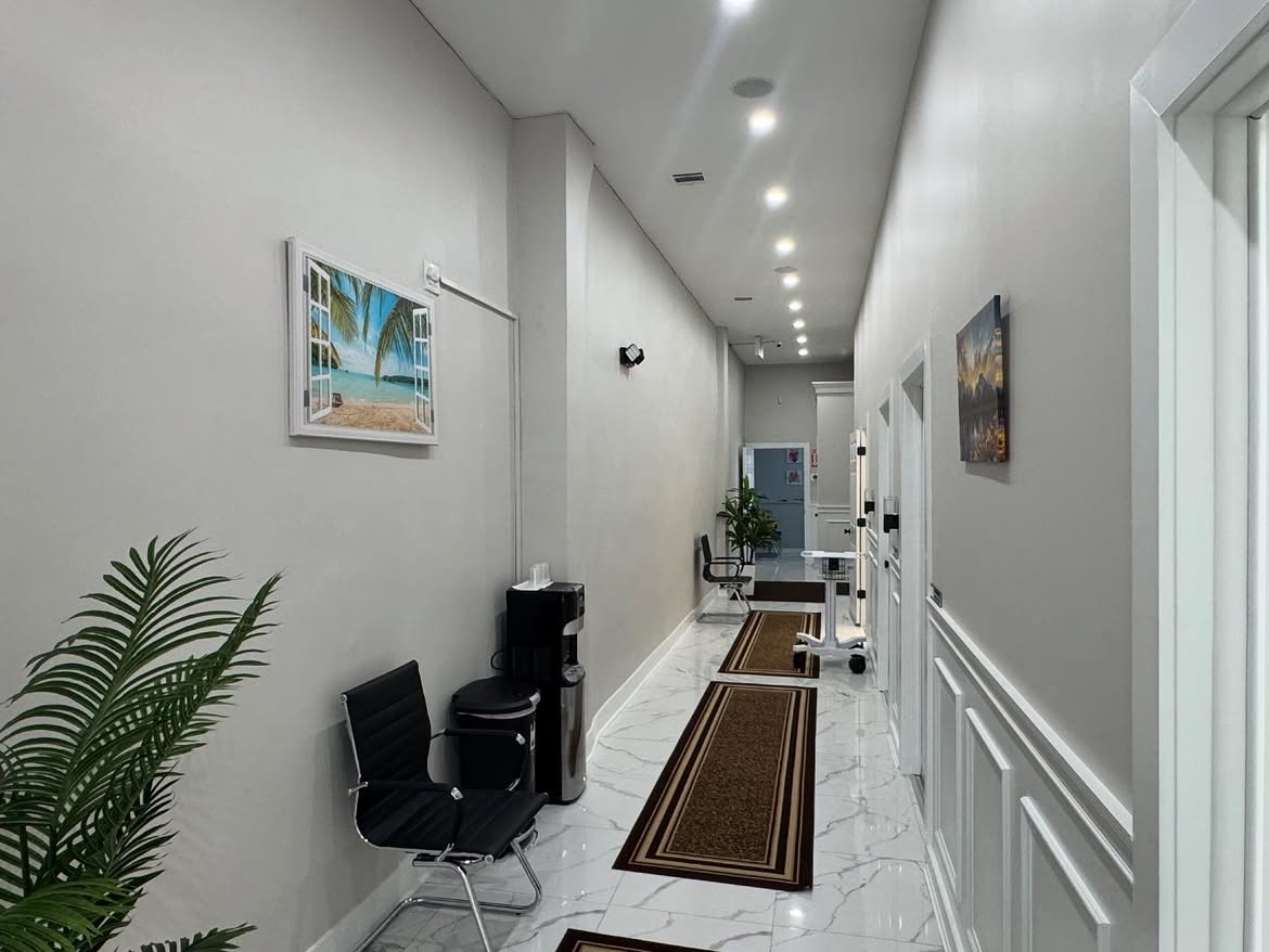 The corridor leading to the exam rooms at the Woodside clinic, with seating and a water cooler along the way.