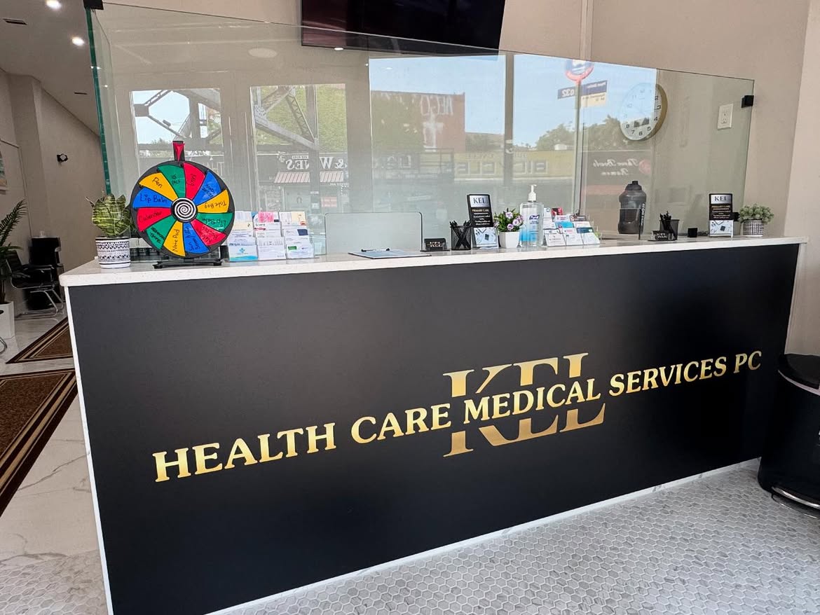 The reception desk at the Woodside clinic, finished in black with the gold Kel Healthcare Medical Services lettering.