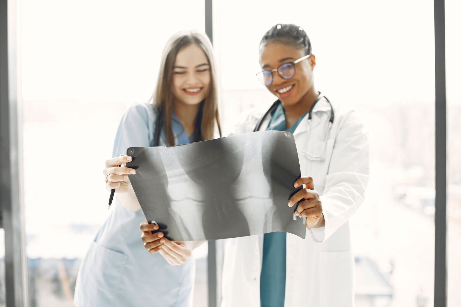 Two clinicians reviewing an X-ray together while coordinating a patient's care.